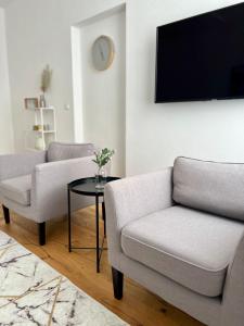 - un salon avec deux chaises et une télévision dans l'établissement Wohnung in Graz, à Graz