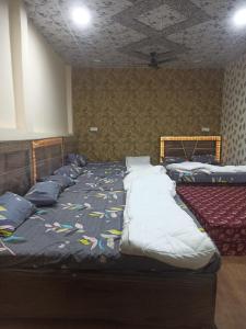 1 dormitorio con 2 camas con almohadas en Shree Kashi Govardhan Dham, en Ujjain