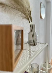 a glass vase sitting on a shelf with a mirror at Große Wohnung in Graz SOVA 1 in Graz