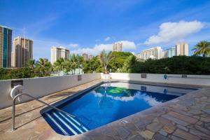 a swimming pool with a city skyline in the background at Studio with gorgeous views tastefully furnished L1514 in Honolulu