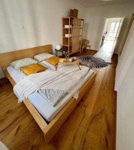 duże łóżko w pokoju z drewnianą podłogą w obiekcie Wohnung in Graz w Grazu
