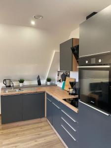 a kitchen with stainless steel appliances and wooden counters at Backstage Oberaudorf in Oberaudorf