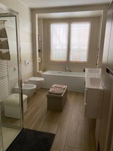 łazienka z wanną, toaletą i umywalką w obiekcie B&B Cascina Sagrestia w mieście Asola