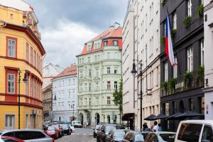 une rue de la ville avec de nombreux bâtiments et voitures garés dans l'établissement 4 Elements Apartments by Adrez, à Prague