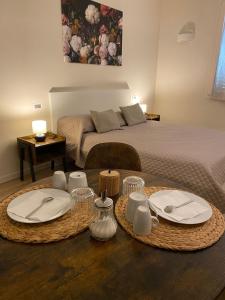 a bedroom with a bed and a table with plates and napkins at B&B Cascina Sagrestia in Asola