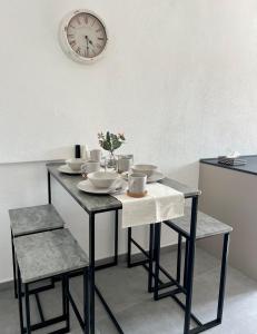 une table avec des chaises et une horloge sur le mur dans l'établissement Wohnung in Graz, à Graz