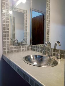 een wastafel met twee kranen en een spiegel bij Residencial Santiago Habitaciones Hotel bed & break fast in Posadas