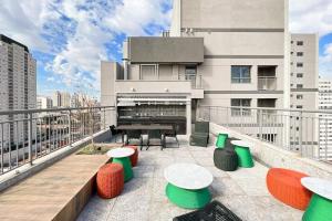 a balcony with tables and chairs on a building at Zainalofts7Vila Mariana ao lado metrô, CASV 11 ID in Sao Paulo