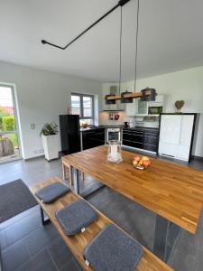sala de estar con mesa de madera y cocina en Villa WanderLux, en Zella-Mehlis