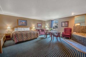um quarto de hotel com uma cama e uma sala de estar em Days Inn by Wyndham Jamestown em Jamestown