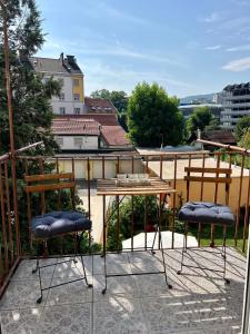 2 chaises et une table sur un balcon dans l'établissement Wohnung in Graz, à Graz