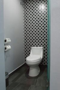 a bathroom with a toilet and a black and white wallpaper at Hotel Flamencos in Mexico City