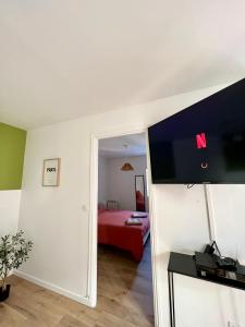 a living room with a television and a bedroom at « Petit Paris » - T2 centre ville Parking/balcon in Albertville +3 photos