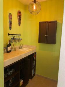 La salle de bains est pourvue d'un lavabo et d'un comptoir aux murs jaunes. dans l'établissement Complex - Real Del Carmen #50, à Playa del Carmen