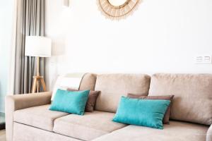 a couch with two blue pillows in a living room at Casa Marina Deluxe II in San Borondón