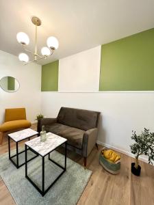 a living room with a couch and two tables at « Petit Paris » - T2 centre ville Parking/balcon in Albertville