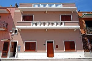 a pink building with a balcony and a balcony at Il Vittoriano in Porto Cesareo