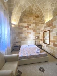 a bedroom with a bed in a brick wall at Il Vittoriano in Porto Cesareo