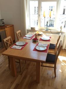 einen Esstisch mit Stühlen und einen Holztisch mit Tellern in der Unterkunft Business Gästehaus Sonne, Mond & Sterne in Bremen