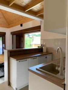 a kitchen with white cabinets and a sink and a window at Vikendica Krlic in Mitrovac