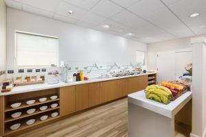 a large kitchen with a counter with fruits and vegetables at Residence Inn West Palm Beach in West Palm Beach