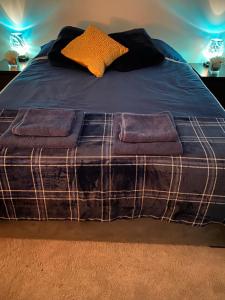 uma cama com cobertores e almofadas roxos em Starlight Cottage Room Only In Glastonbury em Glastonbury