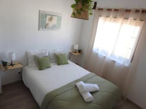 1 dormitorio con 1 cama blanca y 2 toallas en Seacastle Residence Peniche, en Atouguia da Baleia