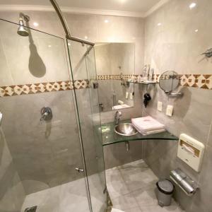 a bathroom with a shower and a sink at Trópicos Motel in Natal