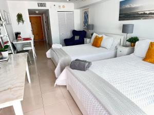 uma sala de estar com duas camas e um sofá em The Stay At Brickell Club em Miami