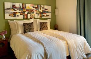 uma cama com lençóis brancos e almofadas num quarto em Gästehaus Casa Cecilia em Wetzikon