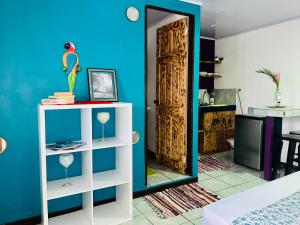 a room with a blue wall and a white shelf and a door at Nomada's Digital in Manuel Antonio