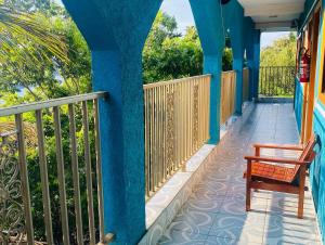 un porche con paredes azules y un banco en el balcón en Pousada 277 en Foz de Iguazú