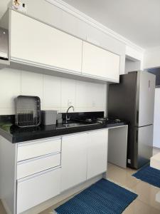 a white kitchen with a sink and a refrigerator at Apartamento Balneário Camboriú in Balneário Camboriú +18 photos