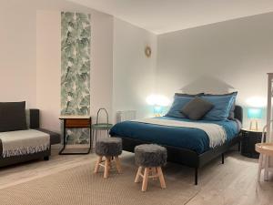 ein Schlafzimmer mit einem Bett und zwei Tischen und einer Couch in der Unterkunft Studio Bienvenue - Louez L'Esprit Libre ! in Bussy-Saint-Georges