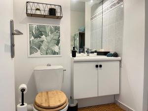 a white bathroom with a toilet and a sink at Studio Bienvenue - Louez L'Esprit Libre ! in Bussy-Saint-Georges