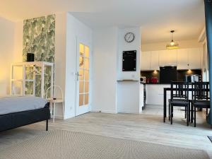 ein Zimmer mit einem Bett und eine Küche mit einem Tisch in der Unterkunft Studio Bienvenue - Louez L'Esprit Libre ! in Bussy-Saint-Georges