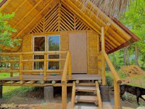 Cette petite cabane en bois dispose d'une véranda et d'un banc. dans l'établissement HOTEL CAMPESTRE LA ISLA, à Villavieja