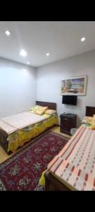 a room with two beds and a rug at VIP Apartment حامعه الدول العربيه Mohandsein in Cairo