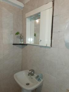een badkamer met een wastafel en een spiegel bij hospedaje El Colibrí in La Unión