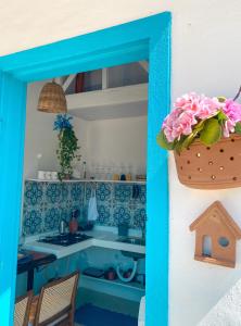 uma cozinha azul e branca com um lavatório e um vaso de flores em Recanto da Sossô em Corumbau