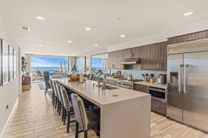 una cocina con una gran isla con sillas. en 19 Feet to the Water - Luxury Oceanfront Home, en Oceanside