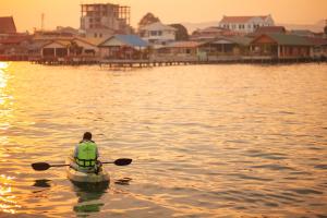 a man in a boat in the water at Baan Tah On The Sea in Bang Sare