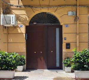 a brown door on a building with plants at Da Mari e Paolo in Palermo