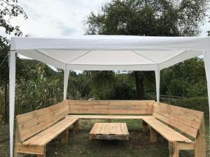 a wooden bench under a white canopy at Dito’s house in Katsʼkhi