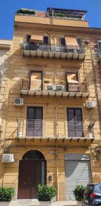 a yellow building with balconies on the side of it at Da Mari e Paolo in Palermo
