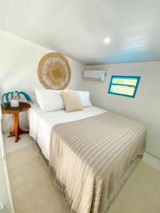 a small bedroom with a bed and a table at Recanto da Sossô in Corumbau