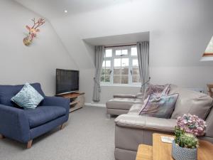 uma sala de estar com dois sofás e uma televisão em Old Seaway Mews em Stokeinteignhead