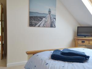 1 dormitorio con 1 cama y una foto de un faro en The Lodge, en Wedmore