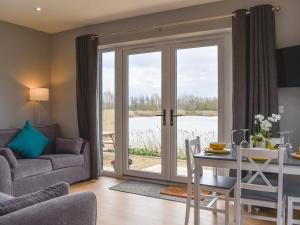 uma sala de estar com uma mesa e uma porta de vidro em Hare Lodge - Uk30604 em Pidley