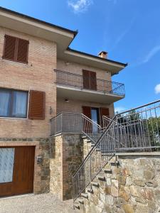une maison en briques avec un escalier en face de celle-ci dans l'établissement Casa Vacanze la Pineta, à Montalcino